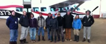 a group of people standing in front of an airplane