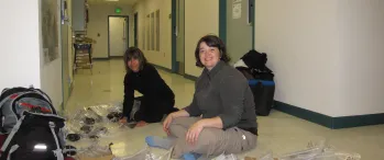 two women sitting on the floor in a hallway