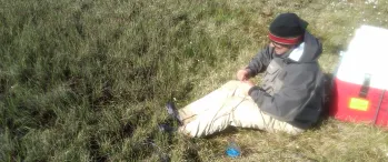 a man sitting on the ground in a field