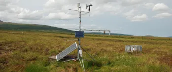 a weather station in a field with a sky background