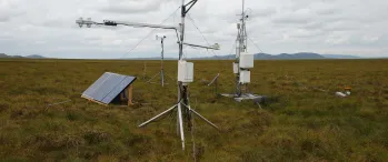 a couple of antennas sitting on top of a lush green field