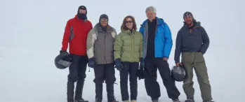 a group of people standing next to each other in the snow